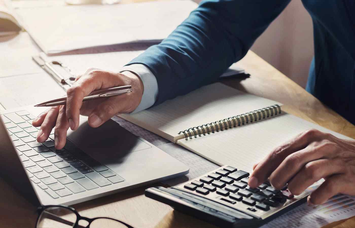 businessman-workig-using-calculator-with-laptop-desk